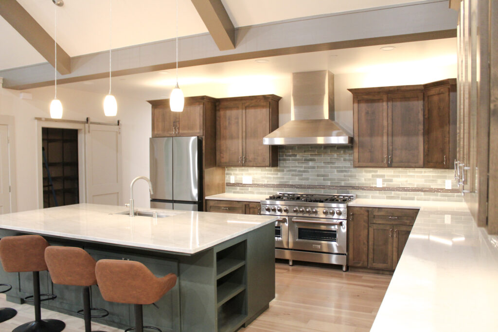 Kitchen remodeling in Ashland, OR with custom wood cabinetry, large island seating, quartz countertops, and modern stainless steel appliances